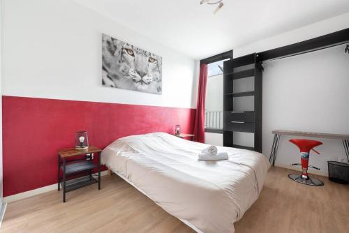 布拉尼亞克的住宿－T3 Terrasse + parking - proche Aéroport et MEET，卧室配有白色的床和红色的墙壁