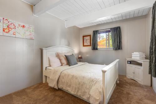 ein Schlafzimmer mit einem weißen Bett und einem Fenster in der Unterkunft Alpine Hideaway in Sugarloaf