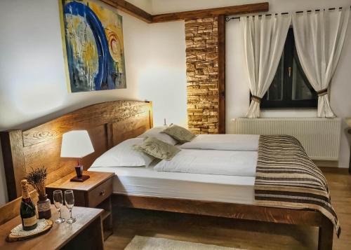 ein Schlafzimmer mit einem Bett und einem Tisch mit einer Lampe in der Unterkunft Etno Garden Exclusive Rooms in Plitvica Selo