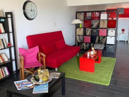 a living room with a red couch and a table at Pinelopis House, Skala Sikamineas, Molivos, Midilli in Skála Sykaminéas