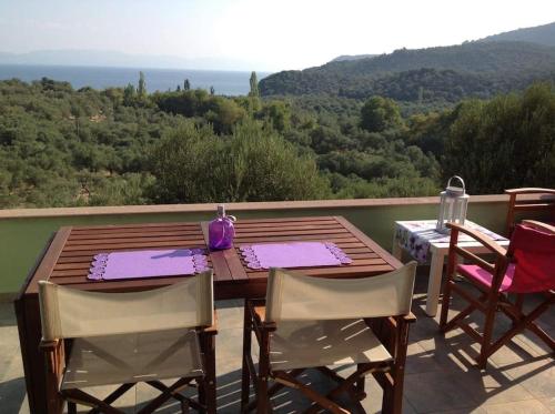 a wooden table and chairs on a balcony with a view at Pinelopis House, Skala Sikamineas, Molivos, Midilli in Skála Sykaminéas