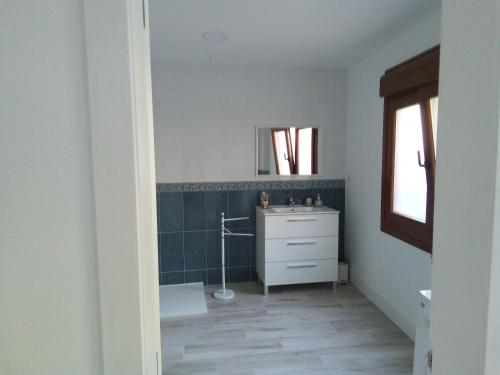 y baño con lavabo y espejo. en Acogedor apartamento a 5 minutos de Sanxenxo, en Pontevedra