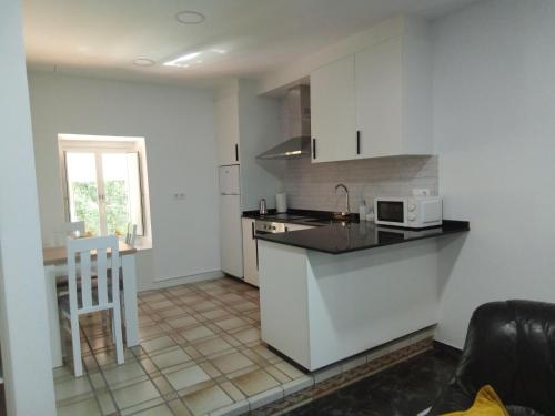 een keuken met witte kasten en een aanrecht bij Acogedor apartamento a 5 minutos de Sanxenxo in Pontevedra