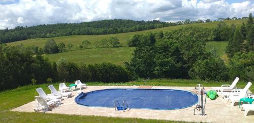 a group of chairs around a swimming pool at Domki WiliCamp in Polańczyk