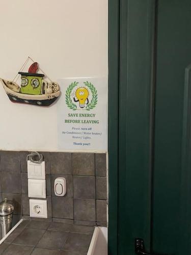 a sign in a bathroom with a toy boat on the wall at Pinelopis House, Skala Sikamineas, Molivos, Midilli in Skála Sykaminéas
