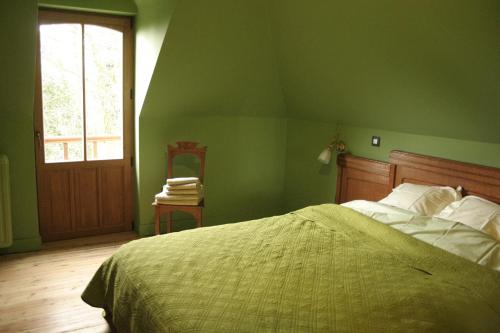 a green bedroom with a bed and a window at N°5 Lumen in Flobecq