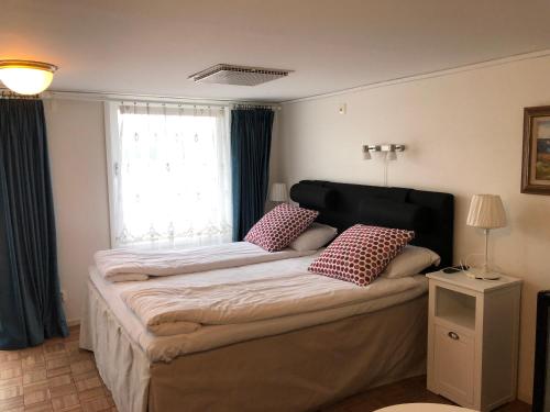 a bedroom with a large bed with two pillows on it at Skulesjön Hotell in Bjästa