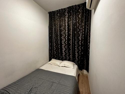 Habitación pequeña con cama y cortina negra en Comfy Family Suite ArtePlus Jalan Ampang en Kuala Lumpur