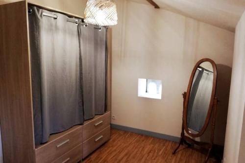 ein Ankleidezimmer mit einem Spiegel und einer Kommode in der Unterkunft La petite maison in Matha