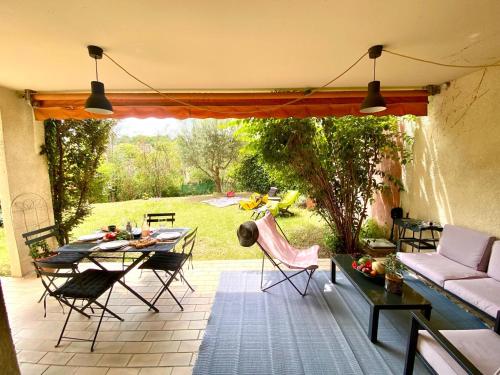eine Terrasse mit einem Sofa, einem Tisch und Stühlen in der Unterkunft Cashmere, Aix en Provence grand T2 avec jardin en ville in Aix-en-Provence
