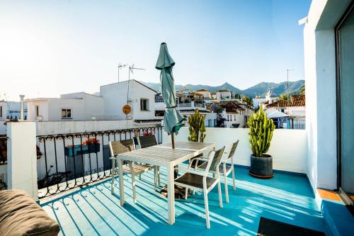 una mesa con sillas y una sombrilla en el balcón en Ancha Village, en Marbella