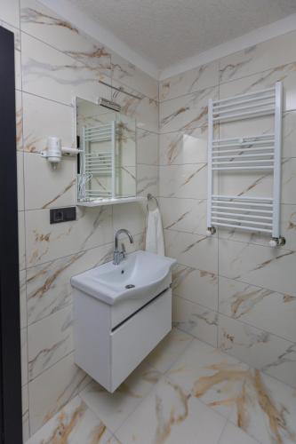 ein weißes Badezimmer mit Waschbecken und Spiegel in der Unterkunft Moonlight Suite in Trabzon