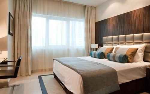 a bedroom with a large bed with a large window at Bonnington Jumeraih Lakes Towers , JLT Cluster J , Dubai in Dubai