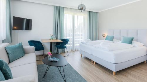 Marienhof Apartments في دروبولاش ام فاكر سى: غرفة معيشة مع أريكة بيضاء وطاولة