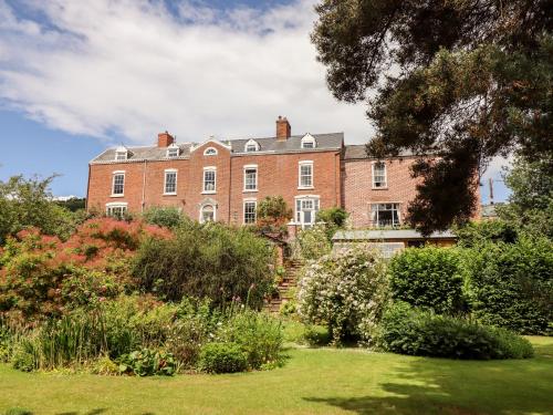 an old brick house with a garden in front of it at Rock House Apartment in Newtown