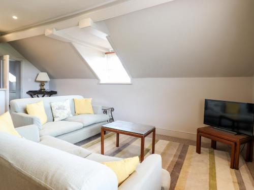 a living room with a couch and a tv at Rock House Apartment in Newtown