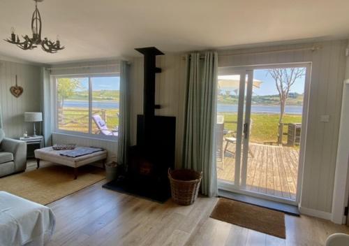 a living room with a bed and a sliding glass door at Eryl in Ferryside