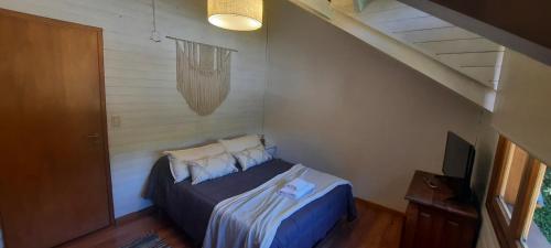 1 dormitorio con 1 cama y TV en Casa Calderon en San Martín de los Andes
