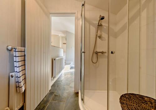 a bathroom with a walk in shower and a glass door at Eryl in Ferryside