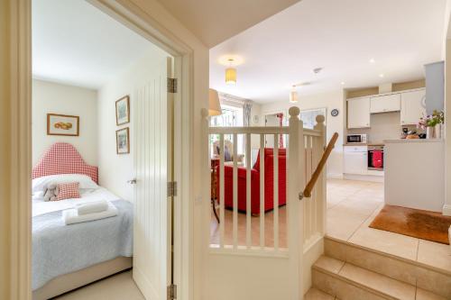a bedroom with a bed and a kitchen at Folly Cottage in Eastdean