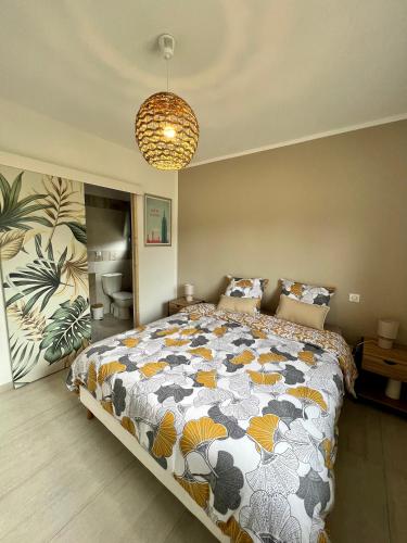 une chambre avec un grand lit et un lustre dans l'établissement Casa Lamaghjone - Villa T4 avec piscine chauffée à 3,5km de la mer, à Aléria