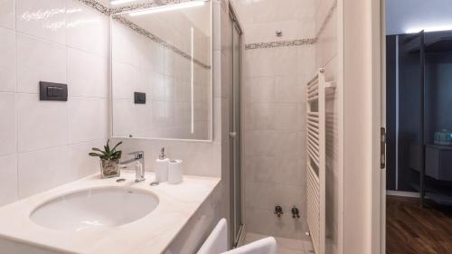 La salle de bains blanche est pourvue d'un lavabo et d'une douche. dans l'établissement VILLA NINETTA 10&1, Emma Villas, à Giulianova