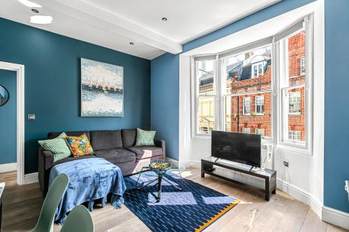 a living room with a couch and a tv at Brighton Lanes by Airhost in Brighton & Hove