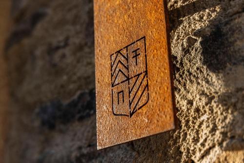 a wooden sign on the side of a wall at Corte Francigena in Montalcino