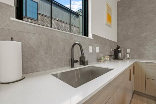 uma cozinha com um grande lavatório e uma janela em The Elegant Estate - Modern Home in Columbus em Columbus
