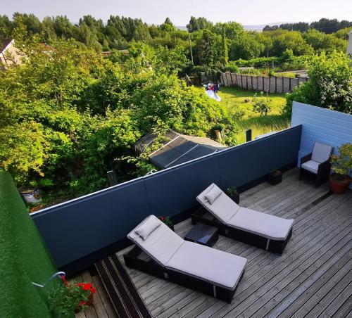 a deck with two chairs and a couple of chairs at Sister's Studio in Llanelli