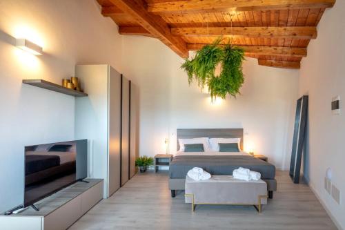 a bedroom with two beds and a flat screen tv at Corte Francigena in Montalcino