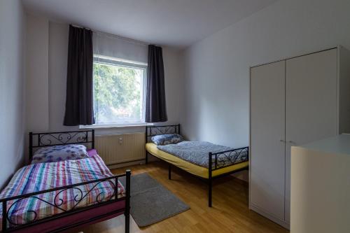 a bedroom with two beds and a window at 3 Zimmer FeWo Karli in Leipzig