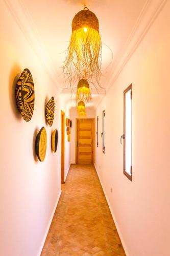 a hallway with a door and a chandelier at Villa Ehzzara piscine chauffée in Essaouira