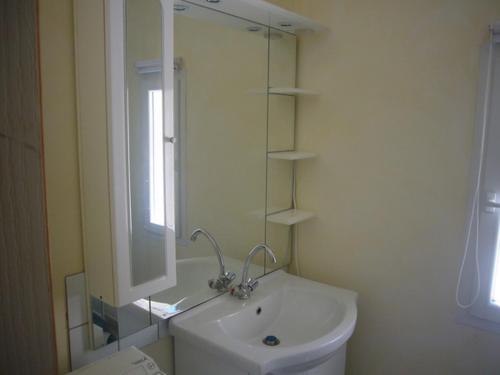 une salle de bain blanche avec un lavabo et un miroir dans l'établissement Goult (LUBERON) A 150 m de la piste cyclable Maison en campagne avec Gde piscine, à Goult