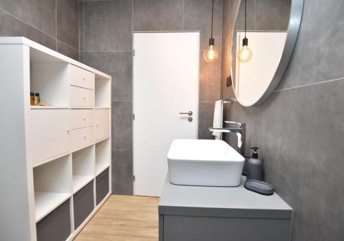 a bathroom with a toilet and a sink and a mirror at Apartment Palcic in Primošten