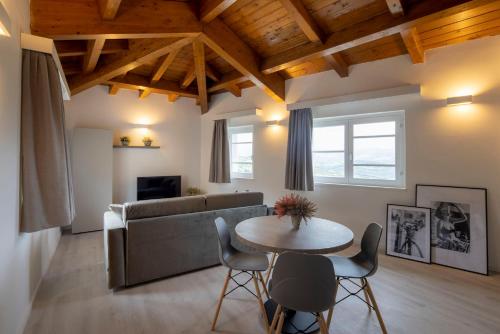 a living room with a couch and a table and chairs at Corte Francigena in Montalcino