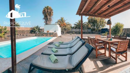 a villa with a pool and a table and chairs at Villa Luz in Lajares