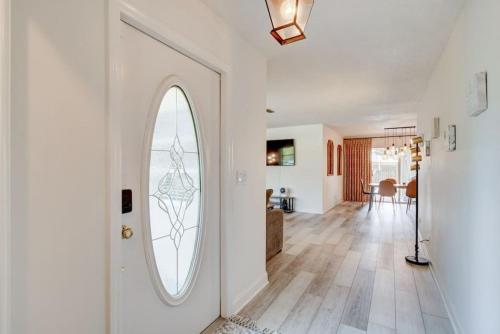 a hallway with a white door with a round window at Boynton 3 2 Pool House in Boynton Beach