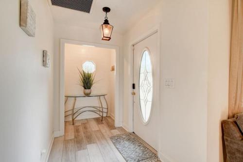 a hallway with a white door and a table at Boynton 3 2 Pool House in Boynton Beach