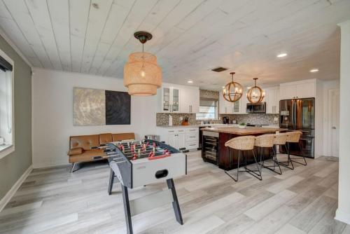 a kitchen with a ping pong table in the middle of a room at Boynton 3 2 Pool House in Boynton Beach