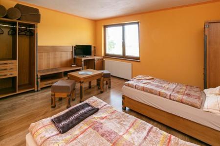 Habitación de hotel con 2 camas, escritorio y mesa en ONYX Penzión en Dudince
