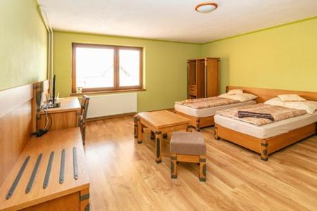 1 Schlafzimmer mit 2 Betten, einem Schreibtisch und einem Fenster in der Unterkunft ONYX Penzión in Dudince