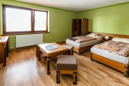 um quarto com 2 camas, uma mesa e uma secretária em ONYX Penzión em Dudince