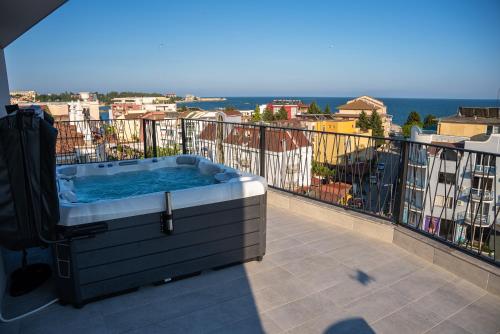 a hot tub sitting on top of a balcony at хотел ADDRESS in Ravda