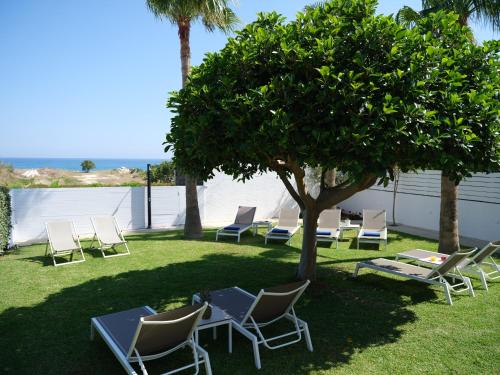 a group of chairs and tables under a tree at Sea La Vie in Adelianos Kampos