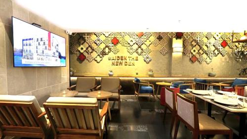 a dining room with tables and chairs and a television at Aiden by Best Western Hennur Bengaluru in Bengaluru