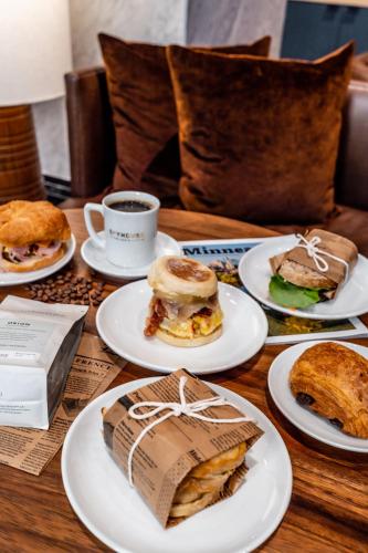 a table with plates of sandwiches and a cup of coffee at Emery Hotel, Autograph Collection in Minneapolis