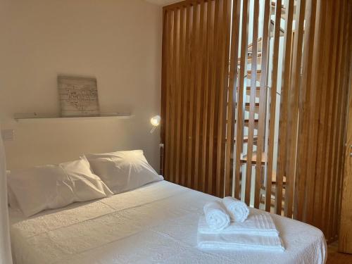 a bedroom with a bed with two towels on it at Gago Coutinho Apartment in São Jacinto