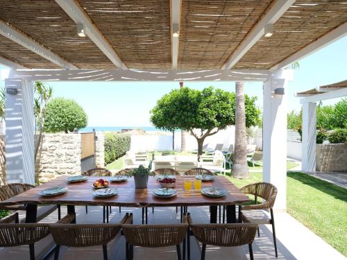 a table and chairs under a pergola on a patio at Sea La Vie in Adelianos Kampos