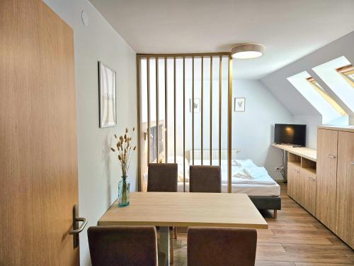 a dining room with a table and a bed at Angela Domki i Pokoje in Pobierowo